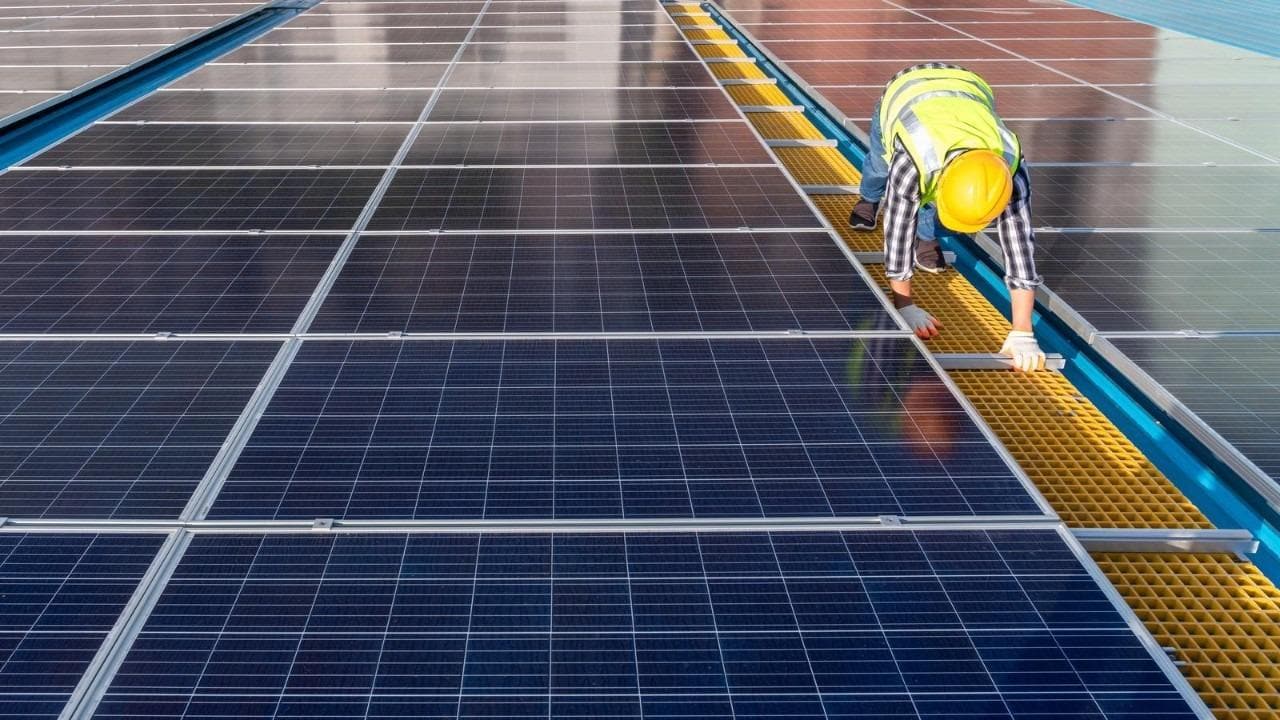 person next to solar panels